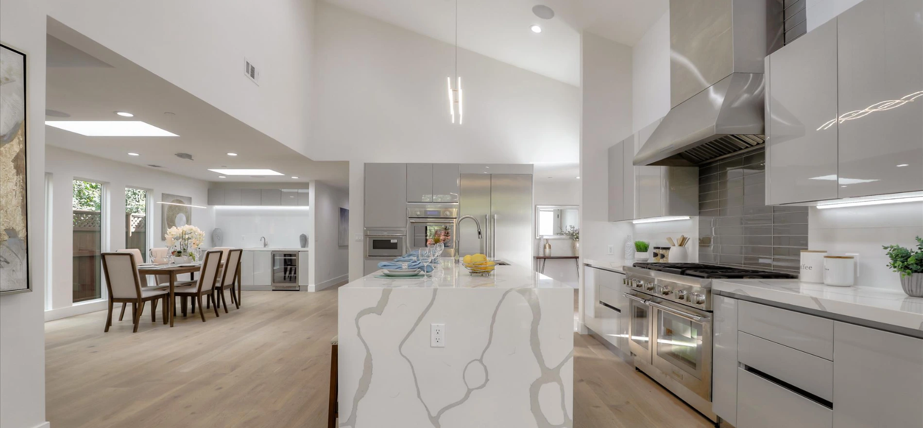 Kitchen and dining area with large vaulted ceilings in remodeled Bay Area home, by Integrity Home Construction
